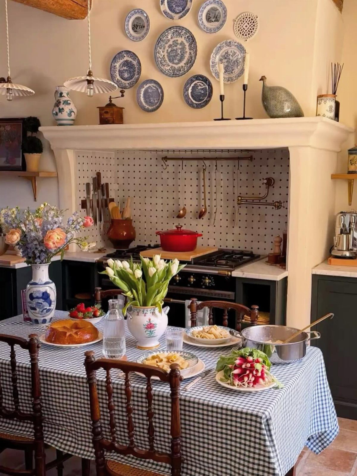 Dining table with checkered cloth, food, and blue and white patterned plates on wall