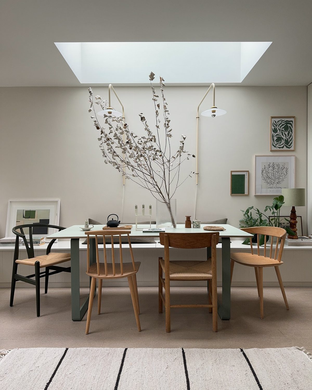 Four different wooden dining chairs surrounding a light-colored table in a bright room.