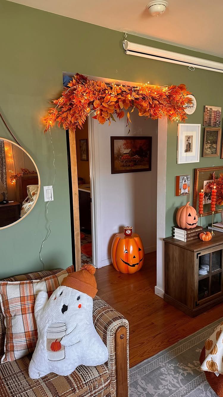 Autumn leaf garland with lights draped over a doorway in a decorated room.