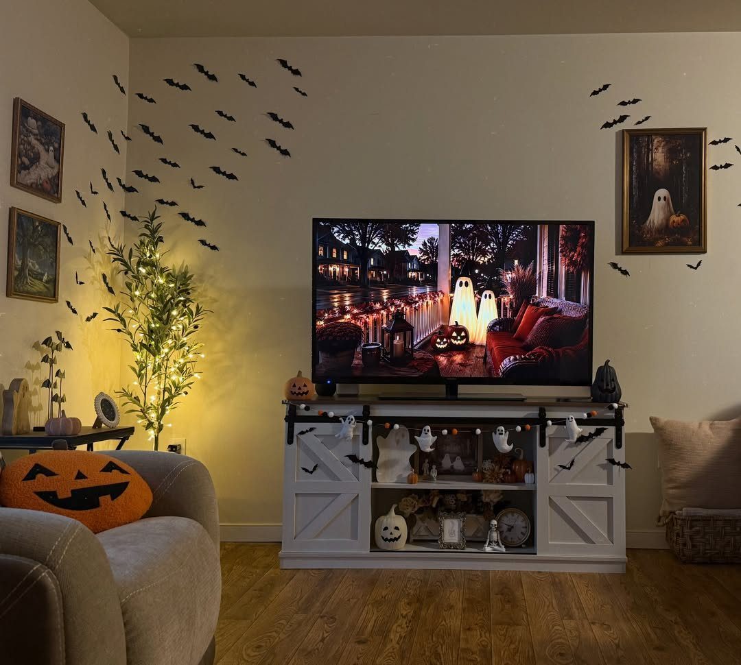 Halloween living room with paper bats on walls and pumpkin pillow on chair