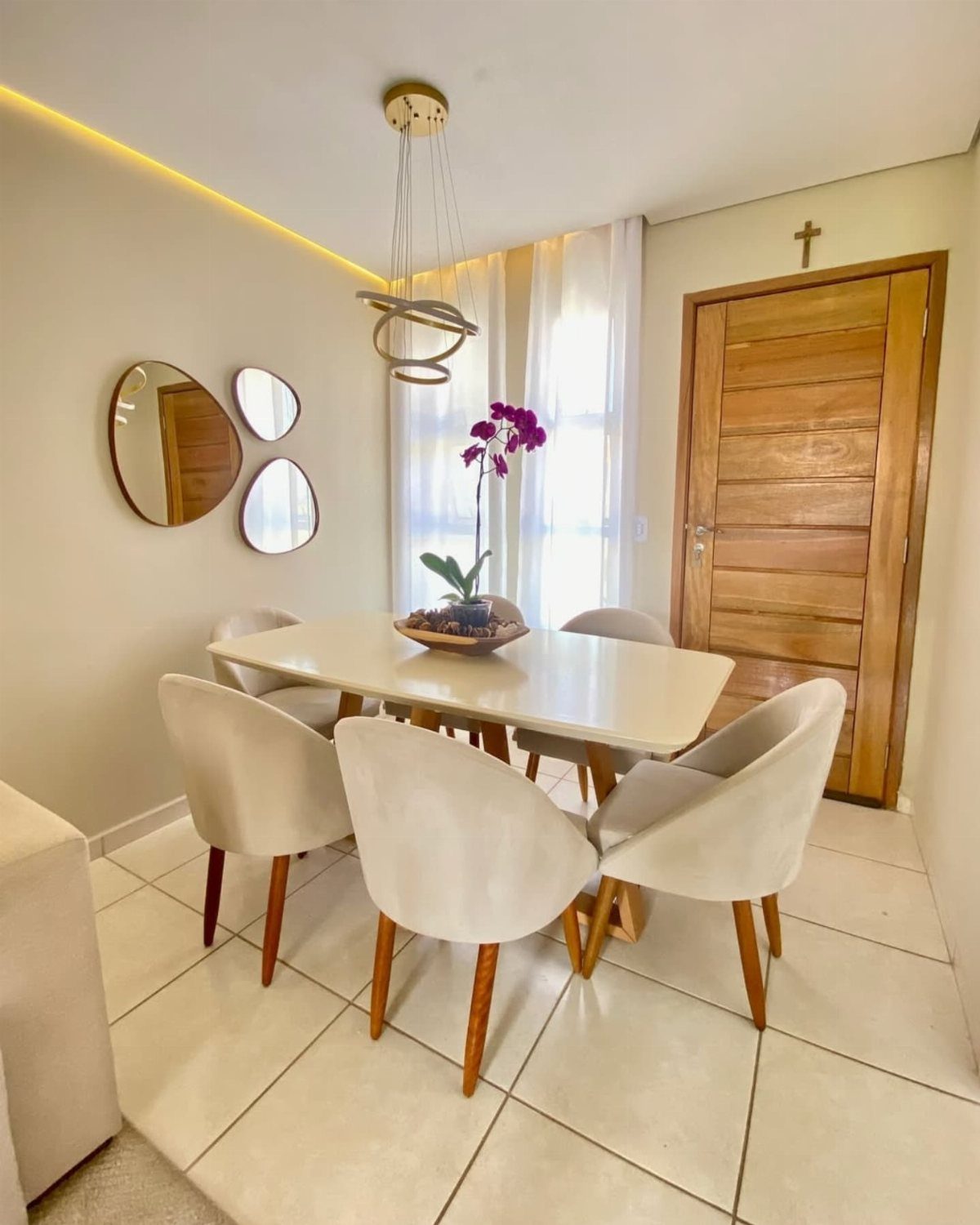 White upholstered dining chairs around a rectangular table in a modern bright room