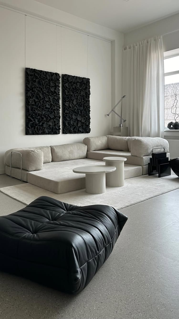 Beige modular sofa and black leather ottoman in a minimalist modern living room