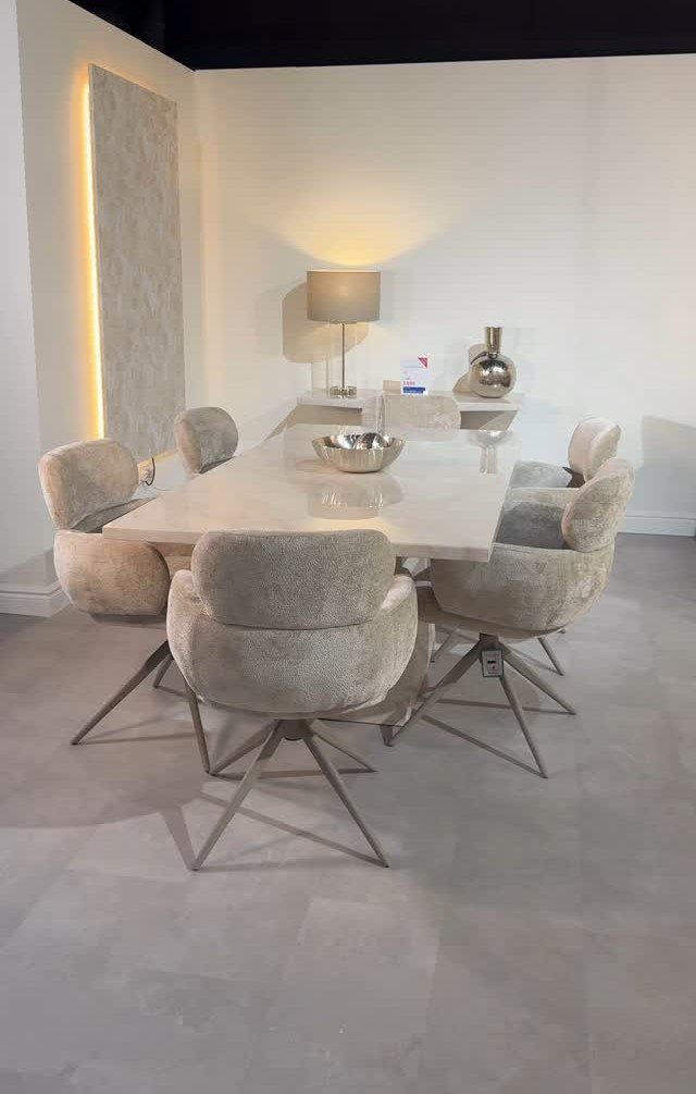 White glossy dining table with matching beige upholstered swivel chairs in modern room