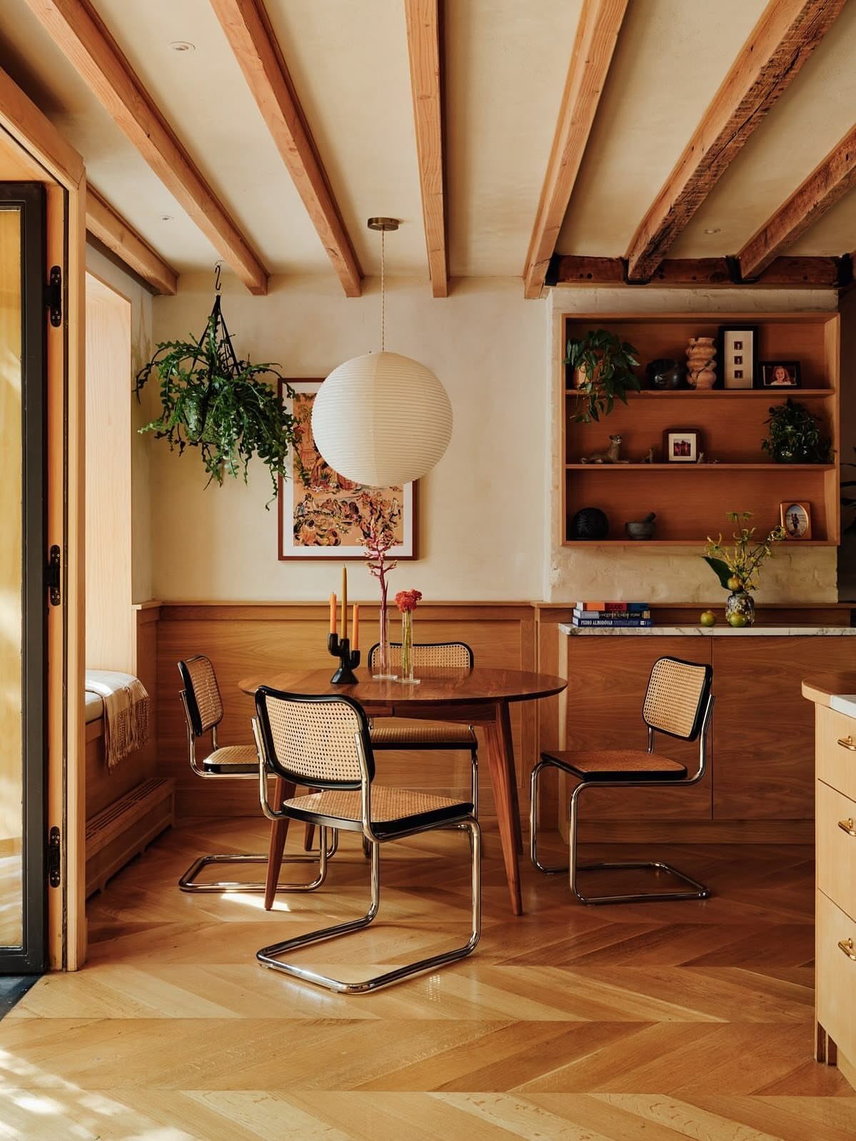 Mid century modern dining room with round wooden table and cane chairs