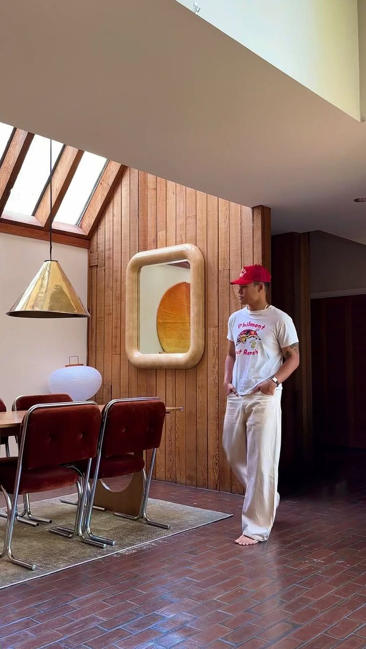 Mid century modern dining room with red leather chairs and wood paneled walls.