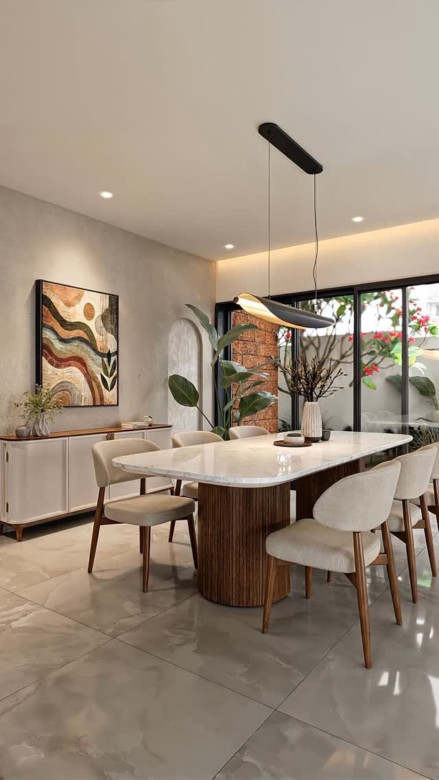 Modern dining room with marble table, beige chairs, and minimalist black pendant lighting.