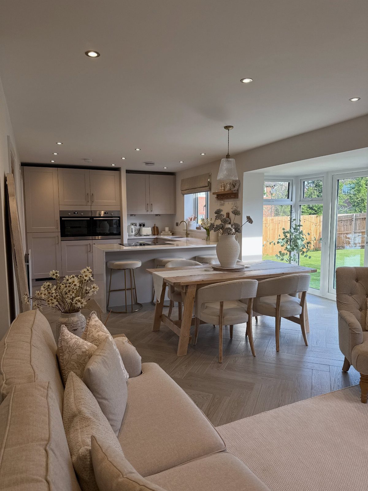 Wooden dining table and chairs situated within an open-concept kitchen and living area.