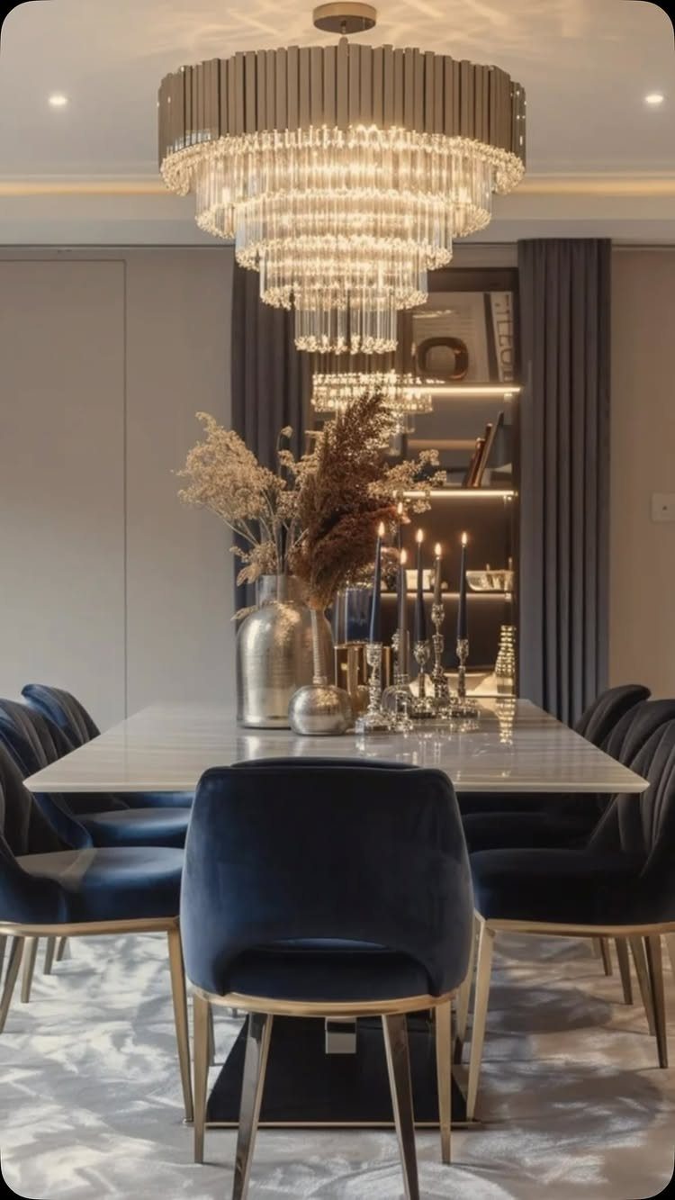Navy blue velvet dining chairs around a white marble table with gold accents.