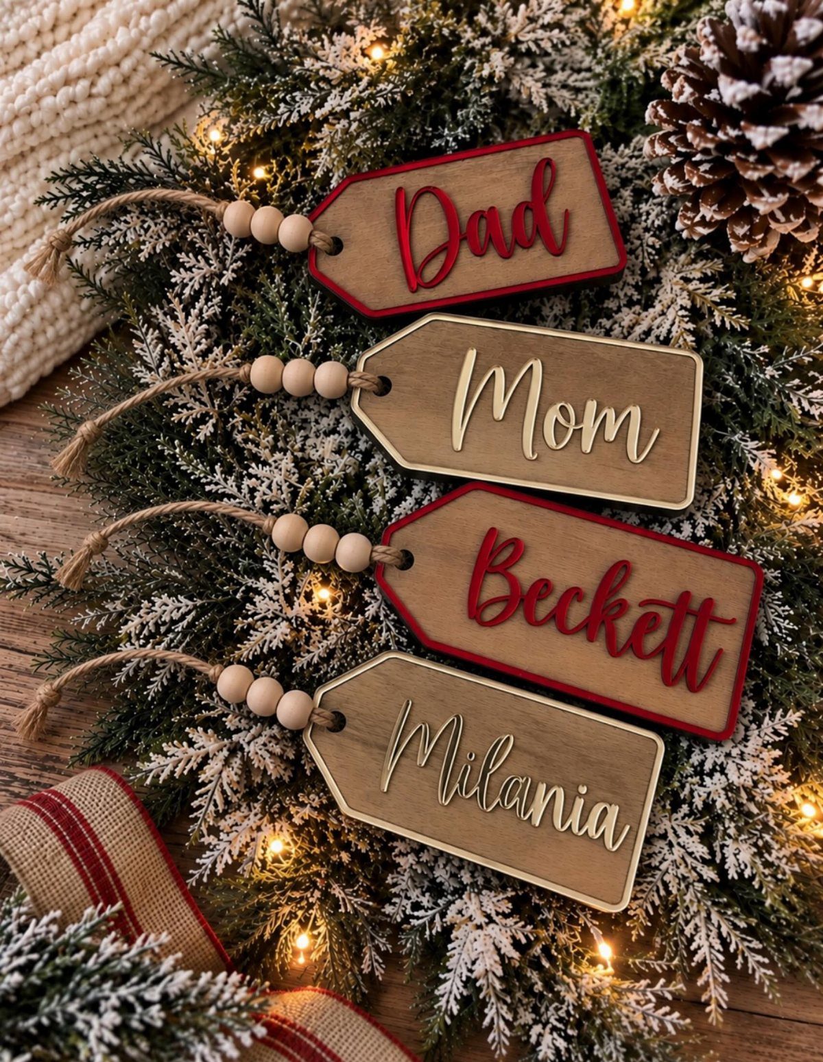Wooden personalized name tags with twine and beads on frosted Christmas greenery