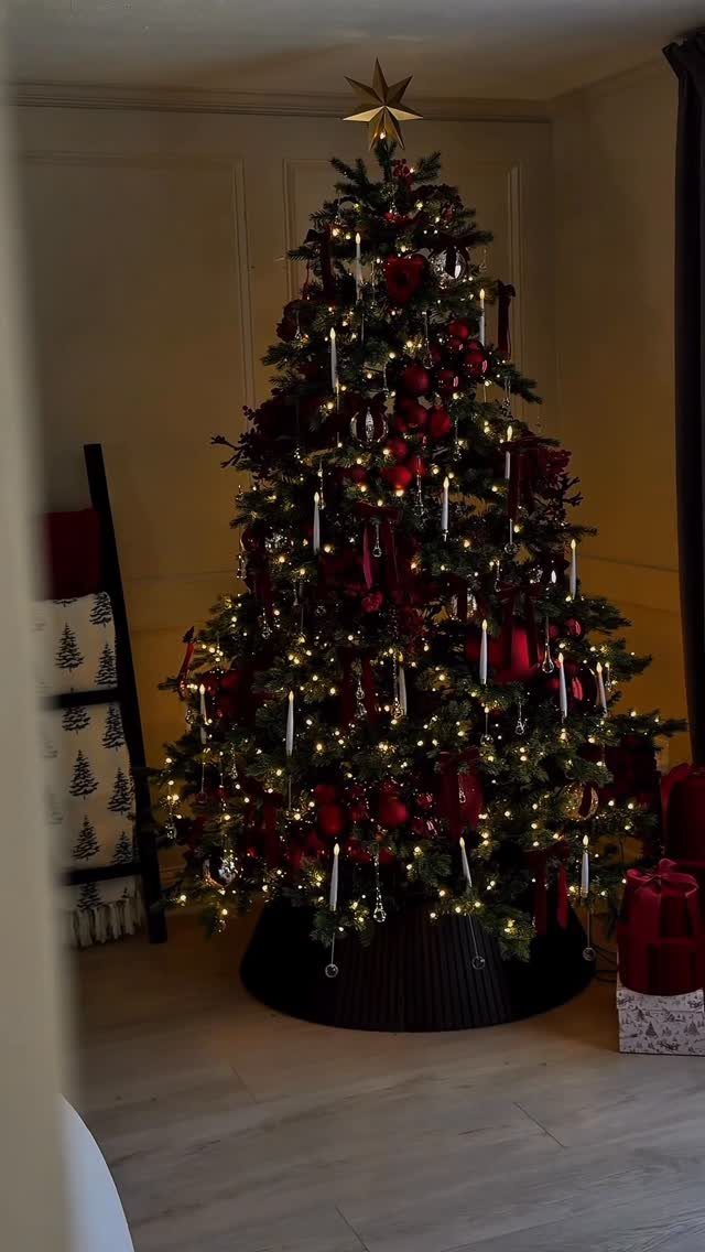 Decorated Christmas tree with warm twinkle lights, red ornaments, and white flameless candles.