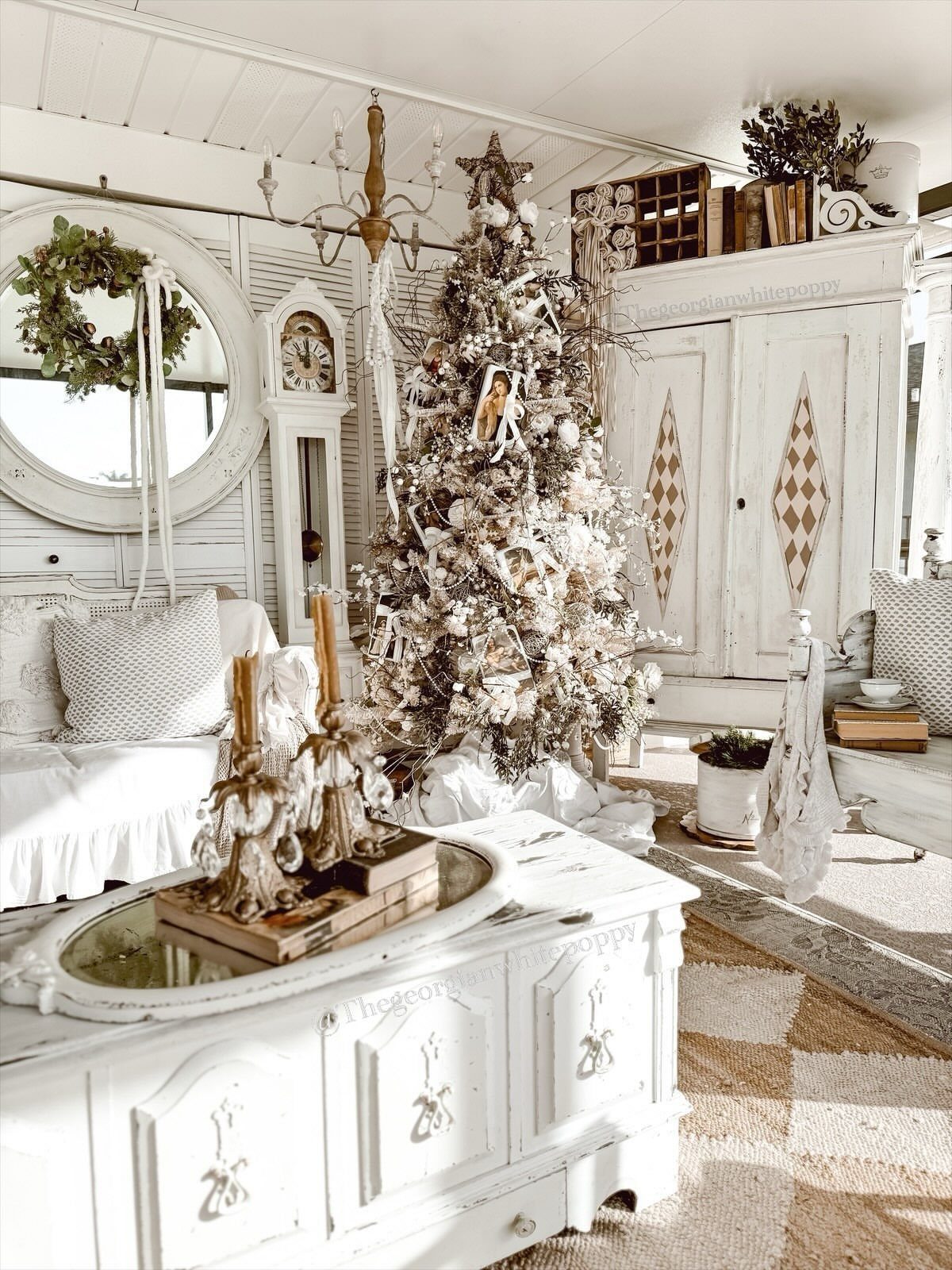 White flocked Christmas tree and wreath on mirror in a rustic white room