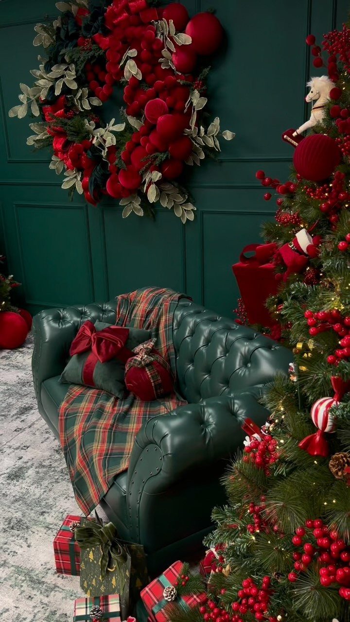 Green leather sofa and Christmas tree decorated with red and green holiday ornaments