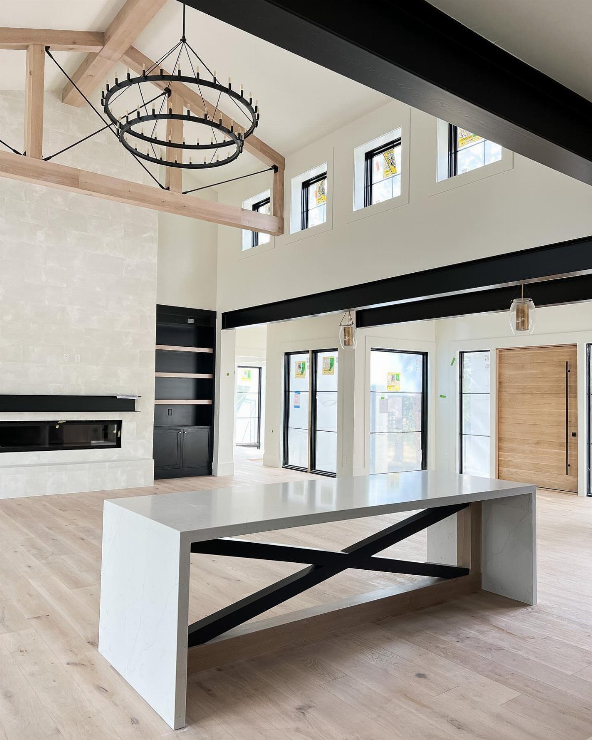 White rectangular dining table with black X-base in a modern, neutral room.