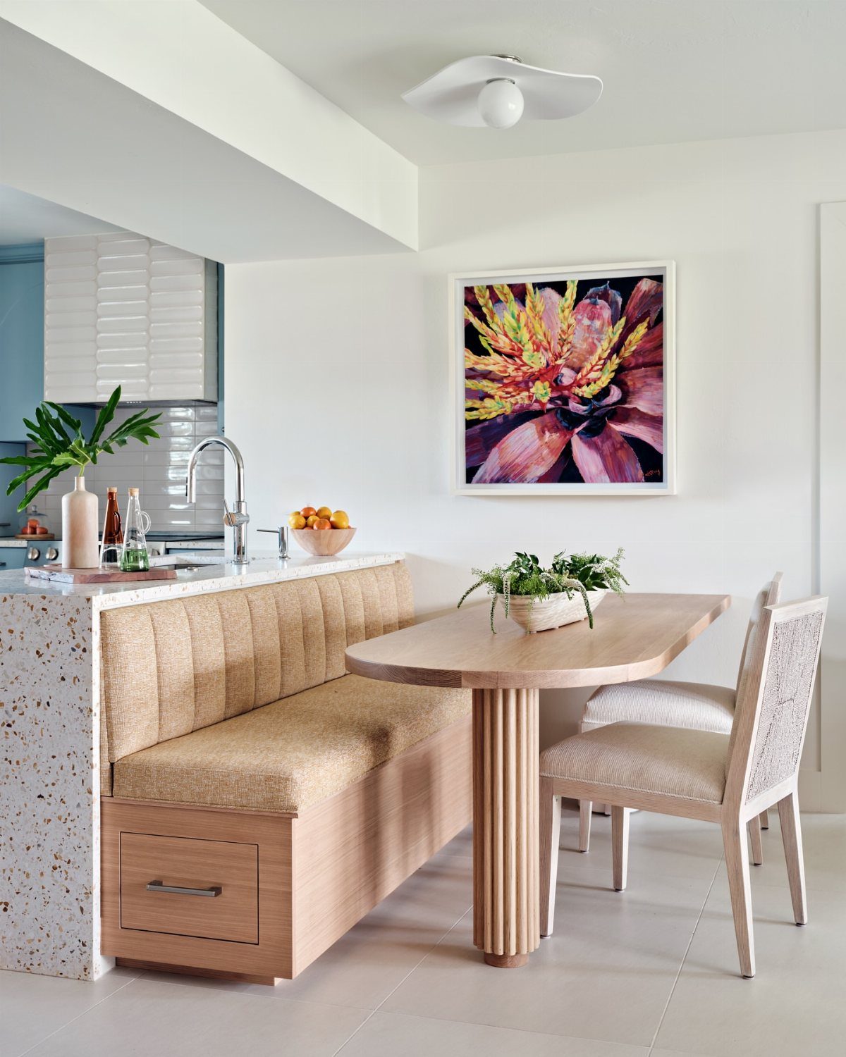 Light wood oval table with a built-in tan bench and woven chairs.