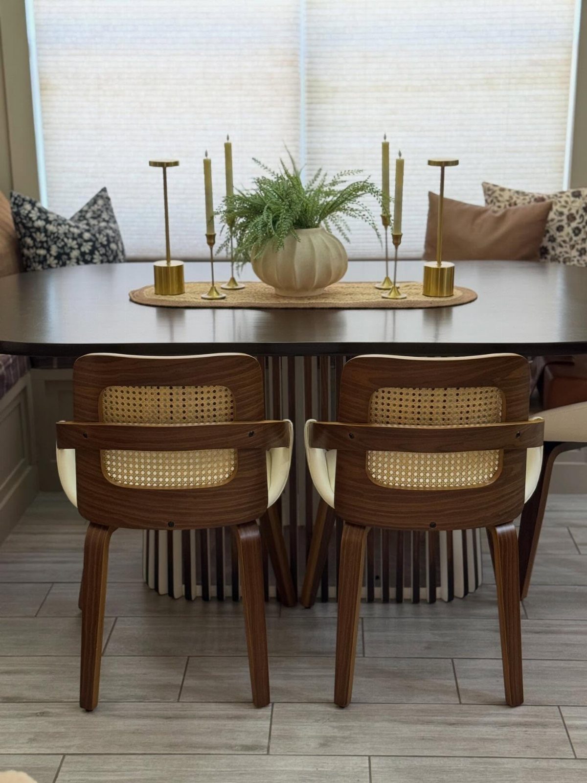 Mid-century modern dining table and cane chairs in a bright breakfast nook setting