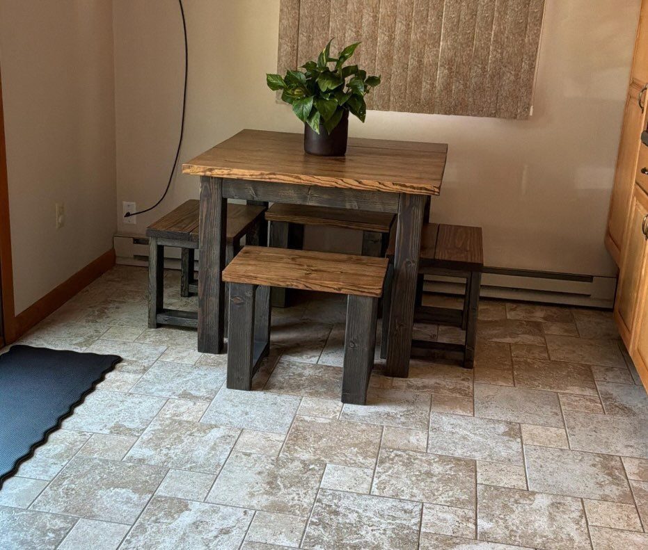 Wooden dining table and benches with a potted plant on tiled flooring