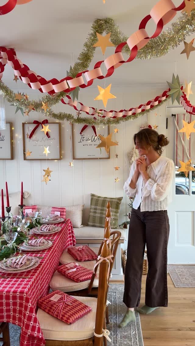 Woman standing by a Christmas decorated dining table with red checkered linens and ribbons.