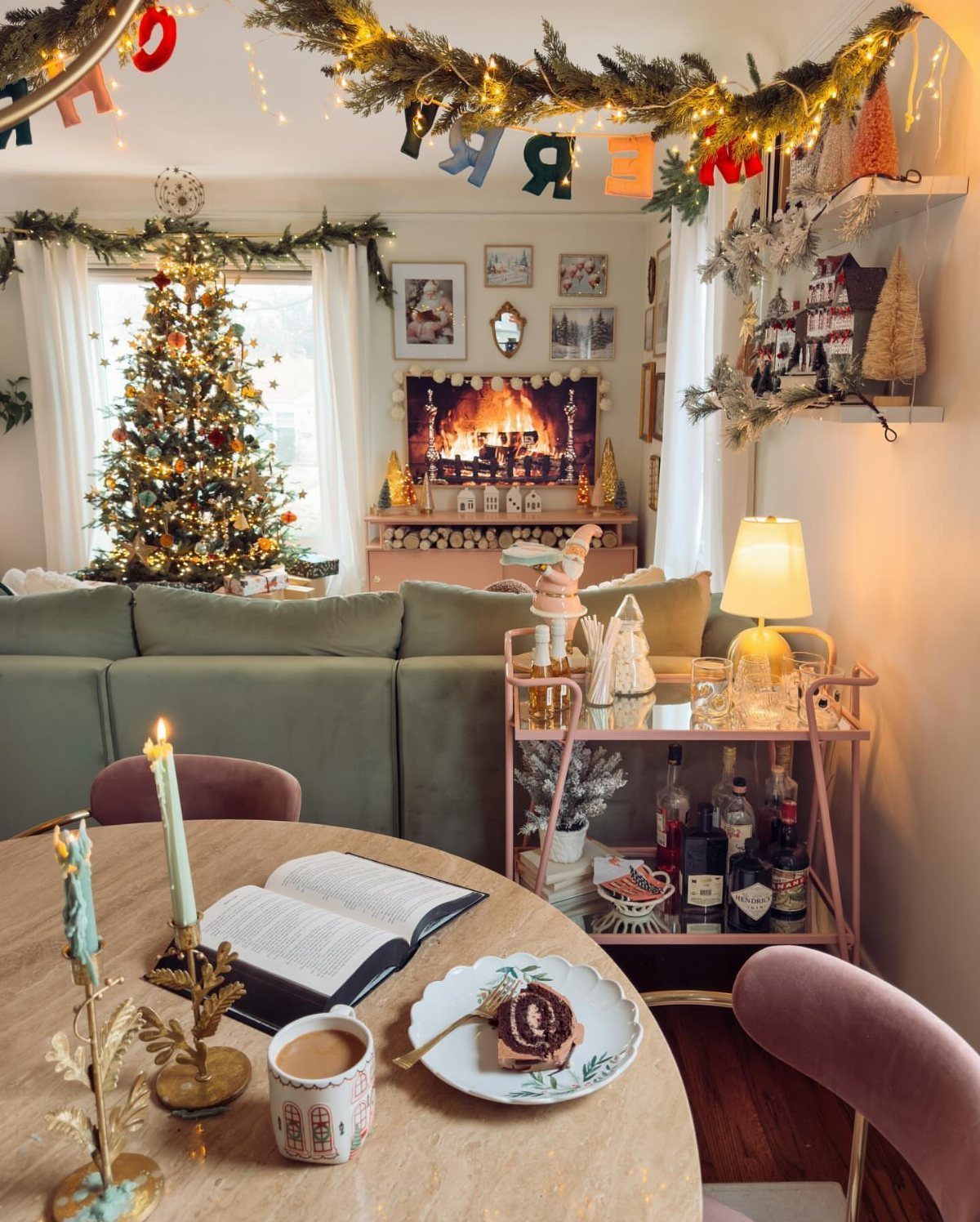 Cozy living room with a Christmas tree, faux fireplace, and festive bar cart.