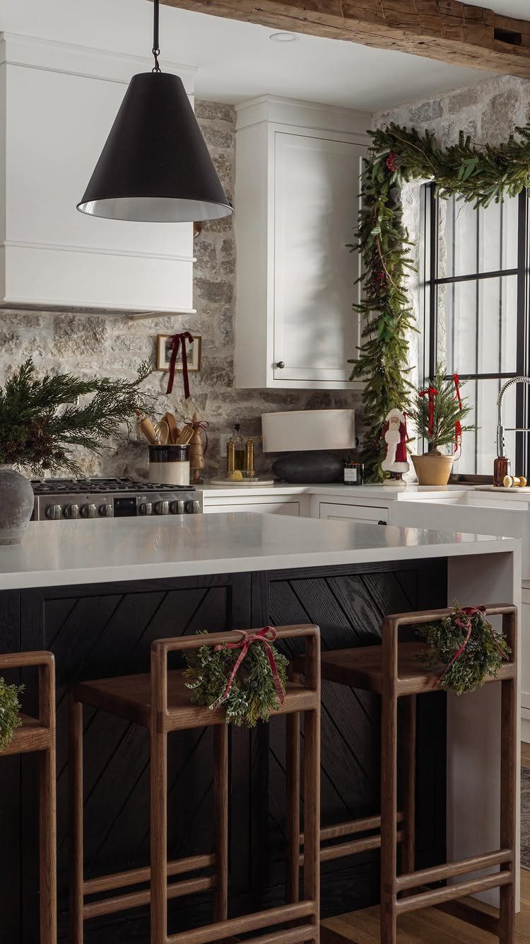 Kitchen interior with simple Christmas greenery on window frames and wooden barstools.