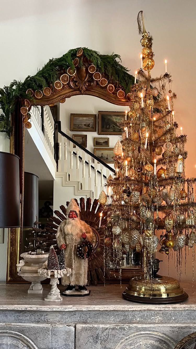 Gold metal tabletop Christmas tree with ornaments and candles on a stone mantel