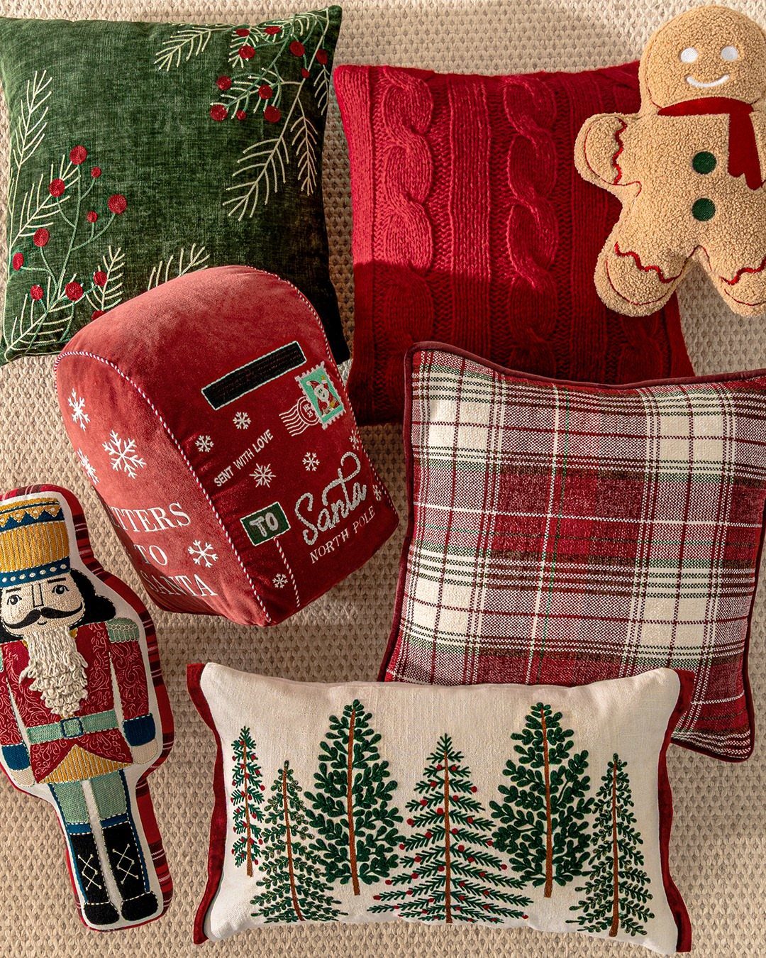 Assorted vintage style Christmas pillows with pine, plaid, and Santa letter designs.