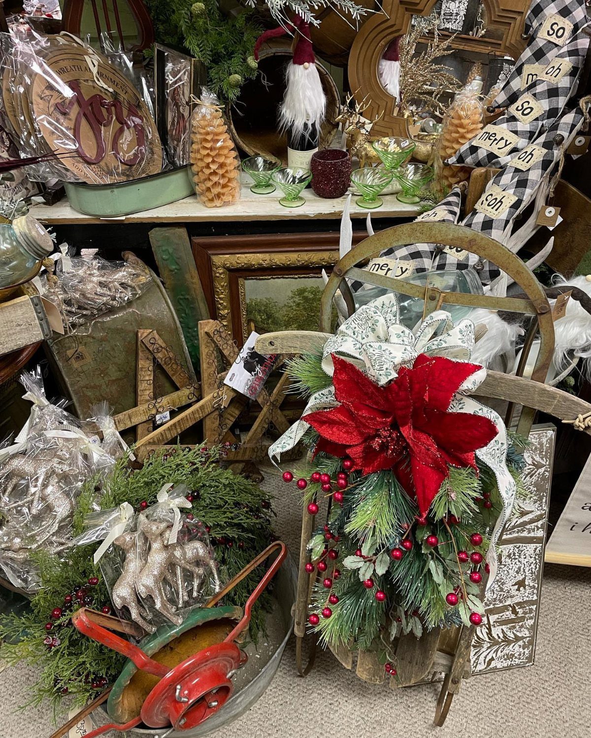 Wooden vintage sled decorated with a red poinsettia and evergreen pine branches.