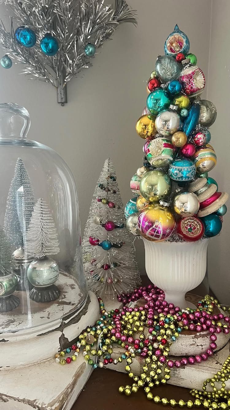 Ornament tree in a white bowl with silver bottle brush trees and beaded garlands.