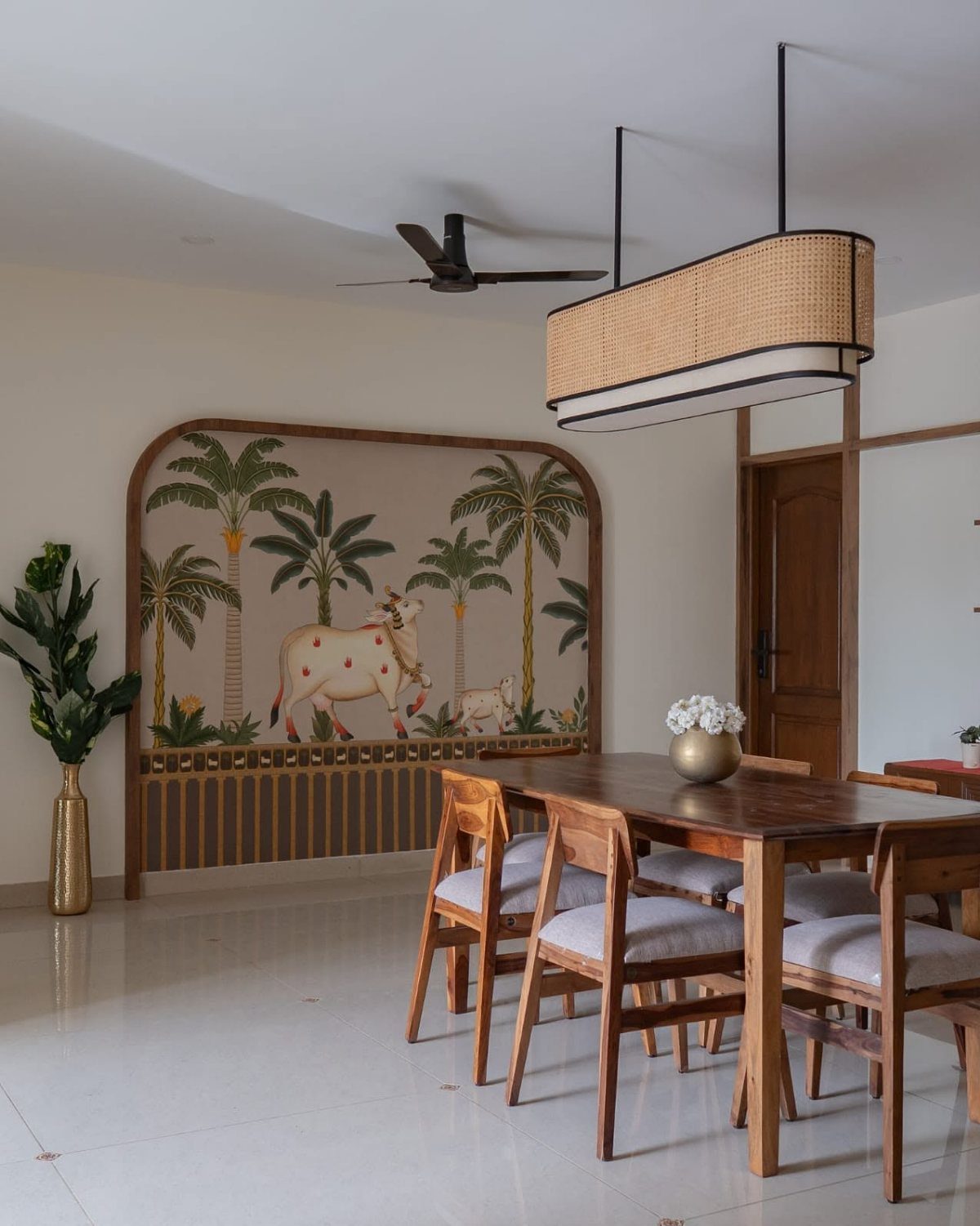 Traditional Indian wall mural of cows and palms in a dining room