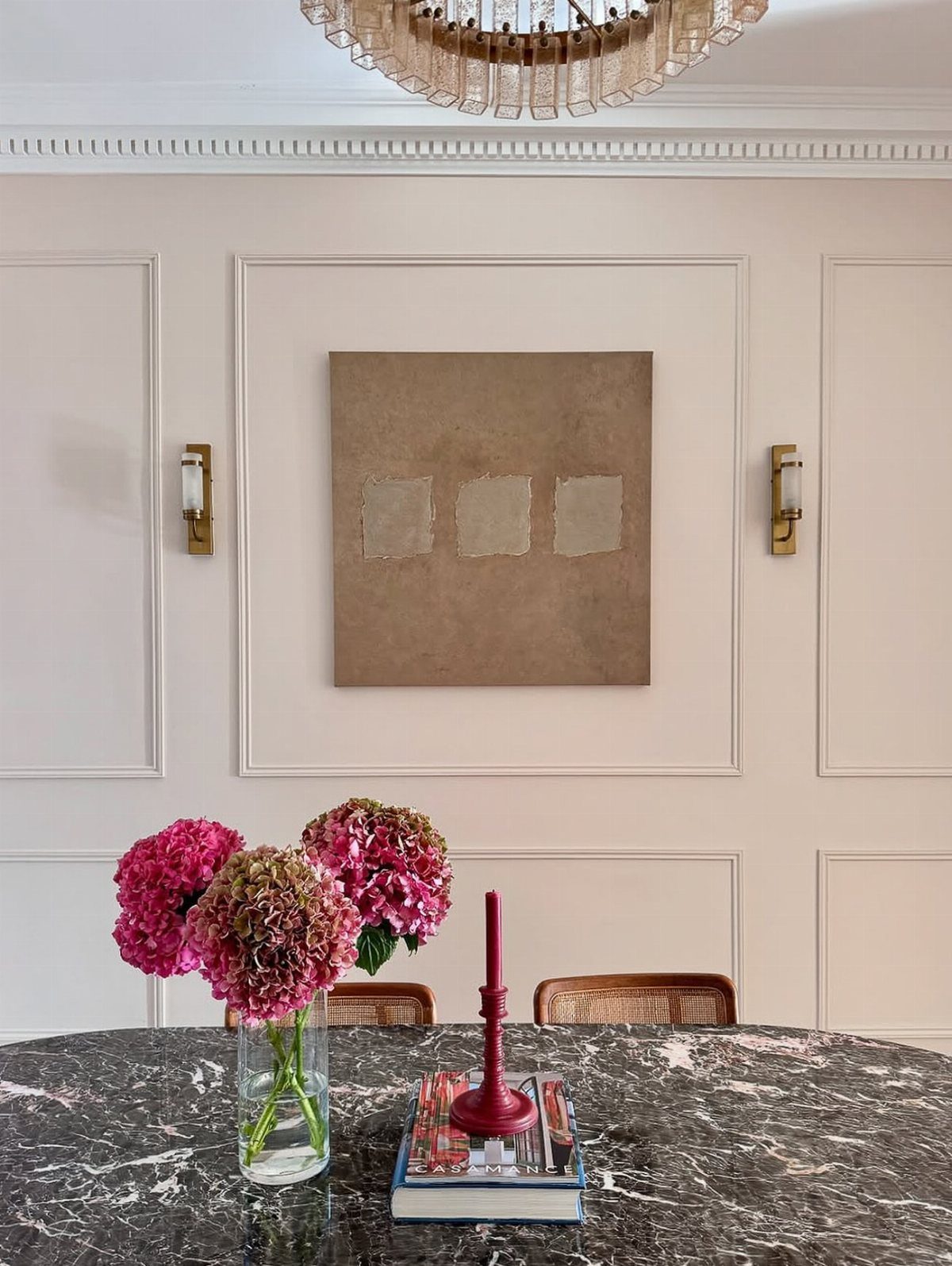 Pale pink dining room walls with marble table and pink hydrangea flowers