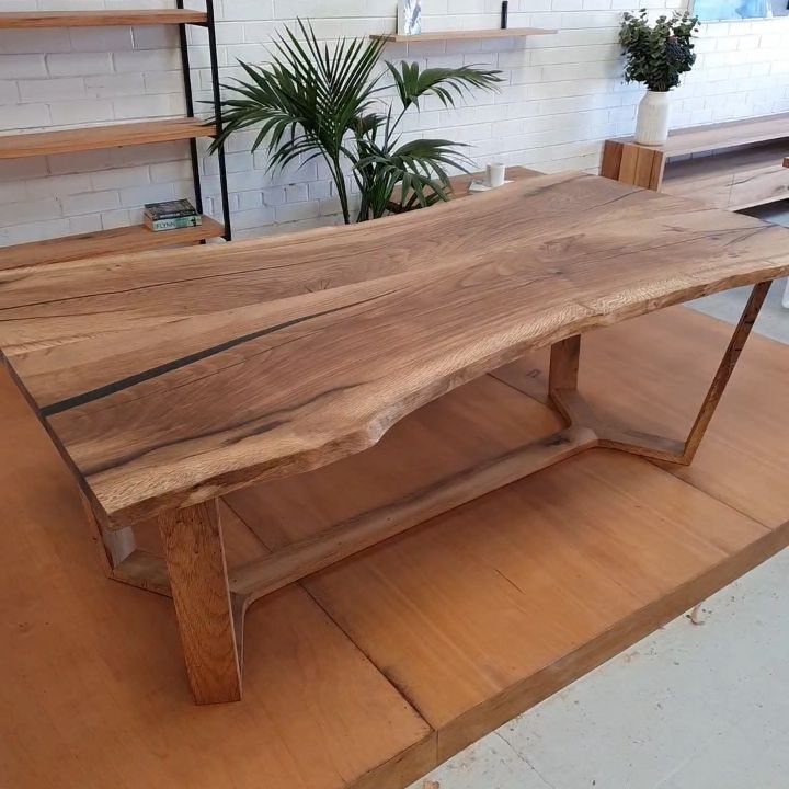 Live-edge wood slab dining table with natural grain and dark resin inlay.
