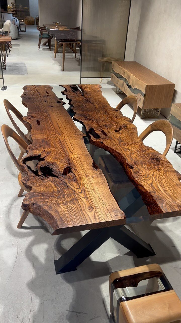 Live-edge wood slab dining table with black metal legs and curved wooden chairs.